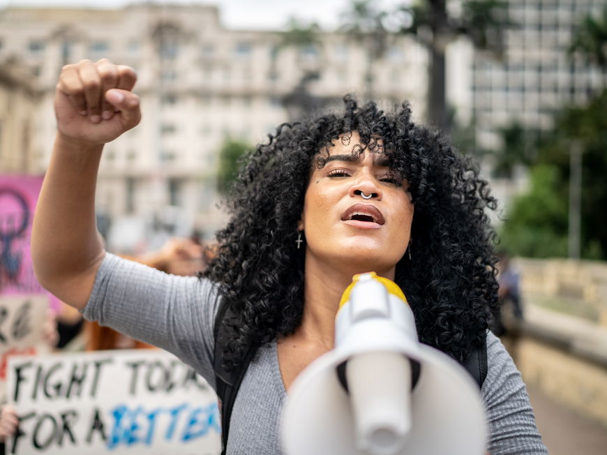Frau hält Megafon bei Demonstration