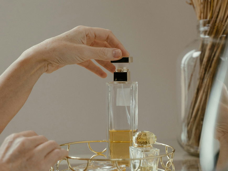 Frau greift zu einem Parfum