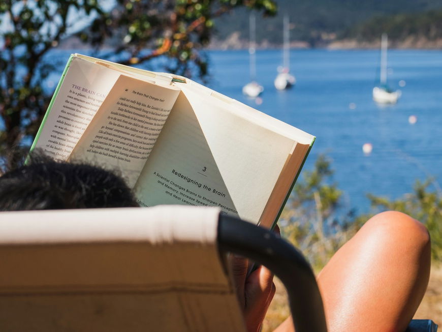 Frau mit Buch am Meer