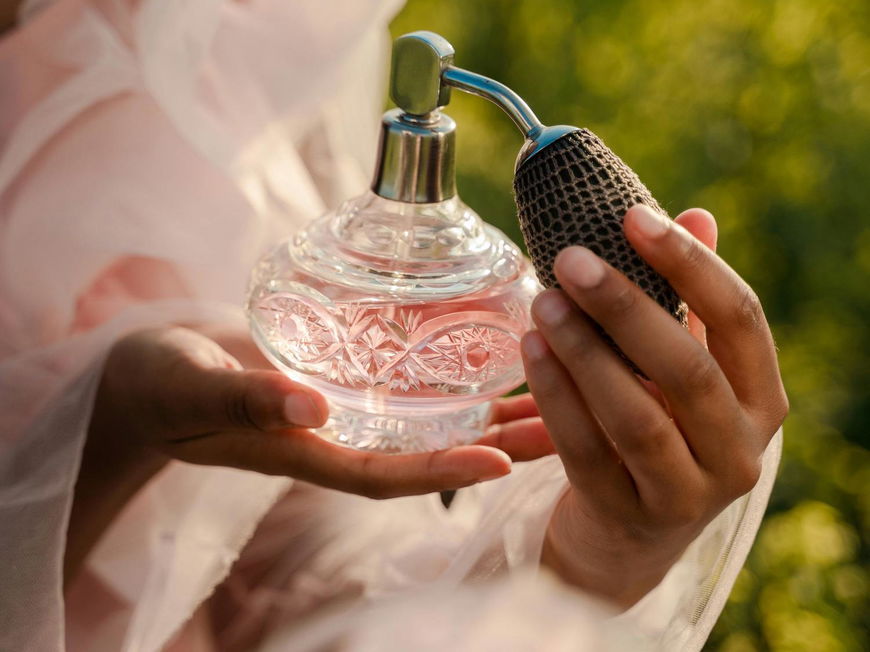 Frau mit Parfum in der Hand