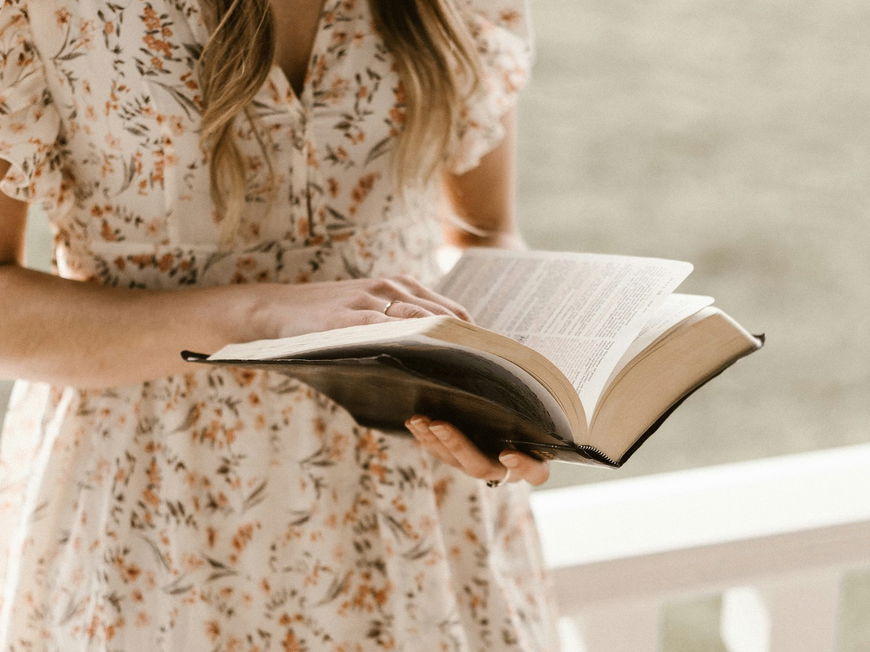 Frau liest Buch auf der Veranda