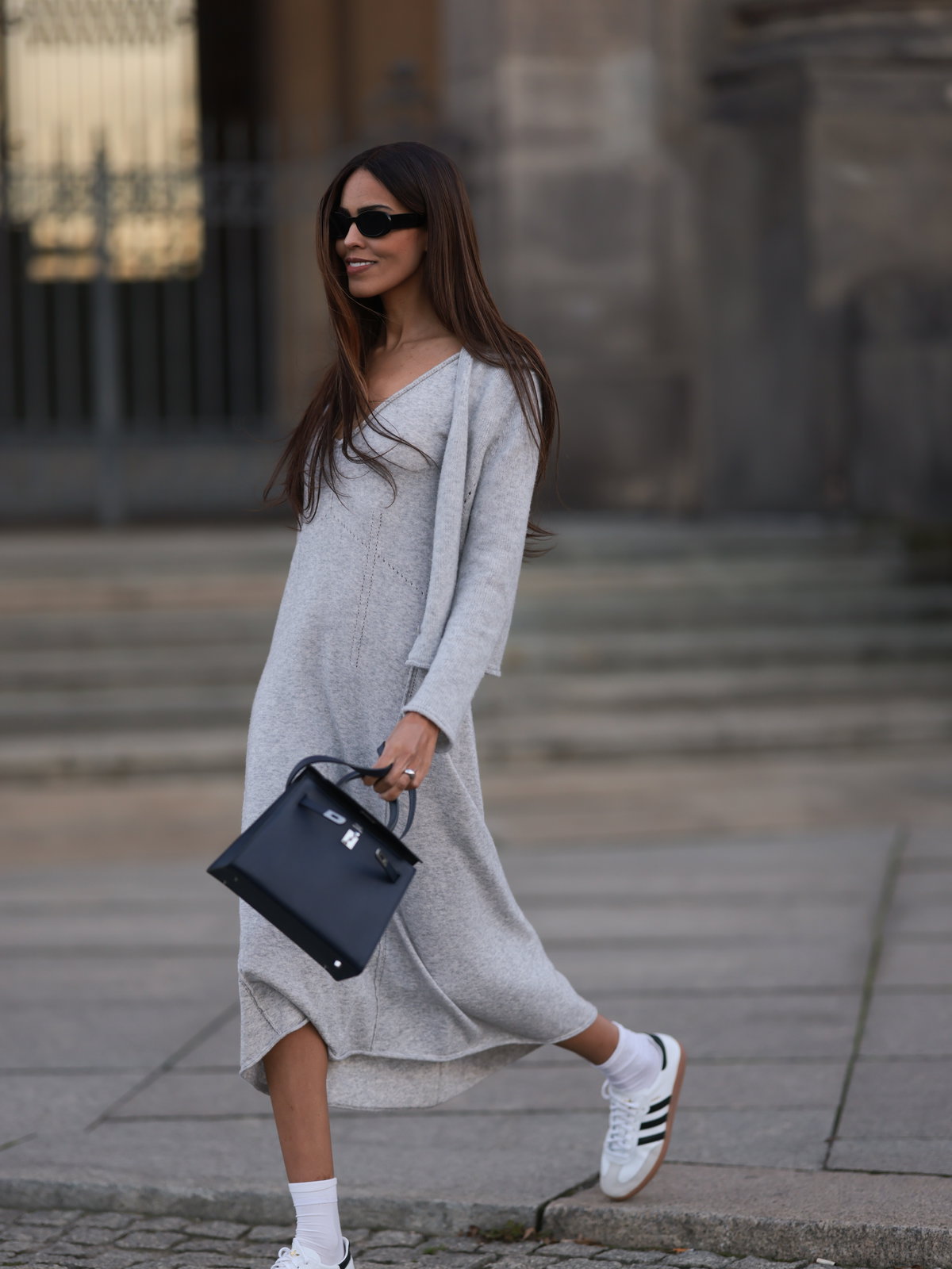 Frau in Midikleid mit Sneakern