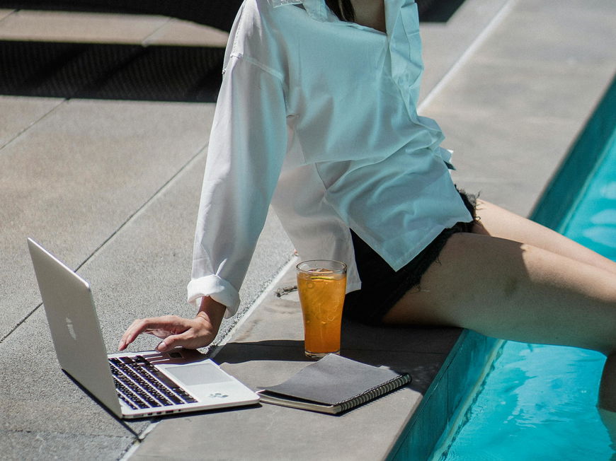 Frau macht "Quiet Vacation" mit Laptop am Pool