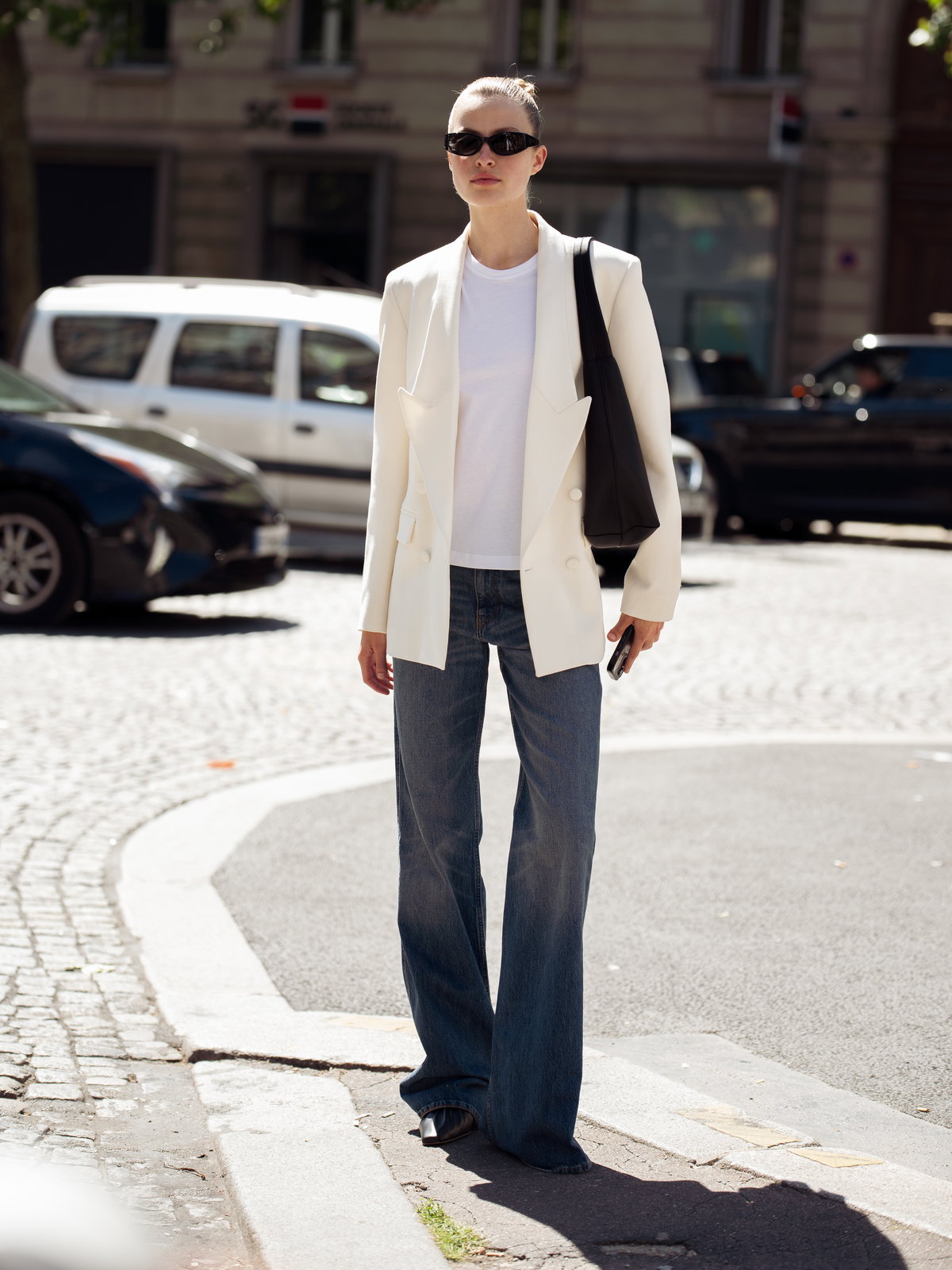 Frau in weißem Blazer mit Jeans
