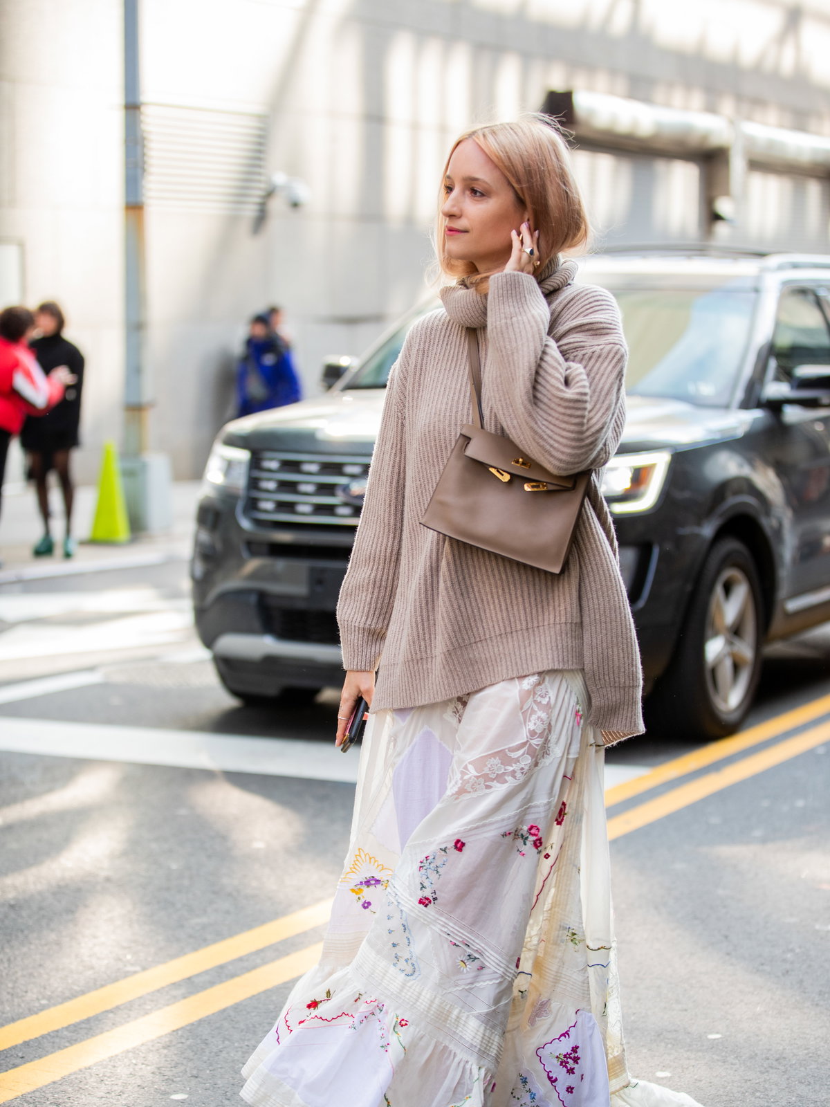 Frau in Sommerkleid und Pullover