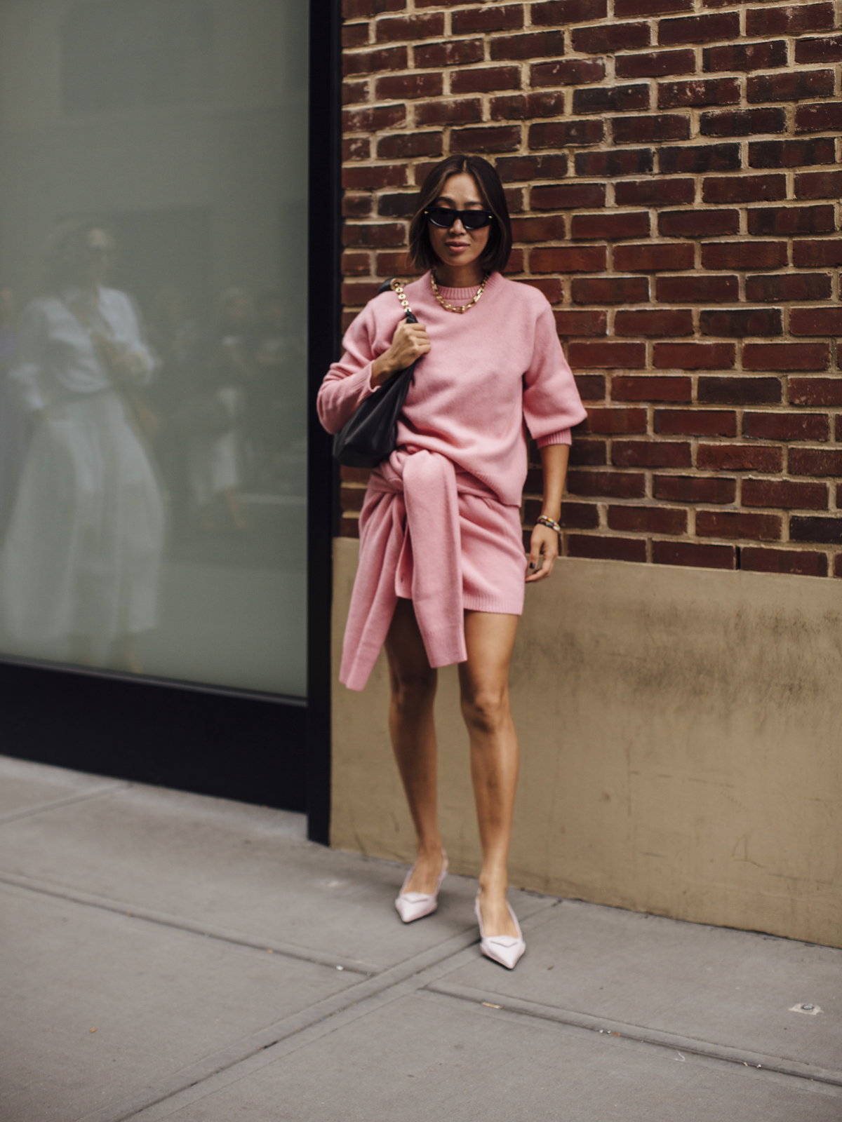 Frau in pinkfarbenem Strickkleid