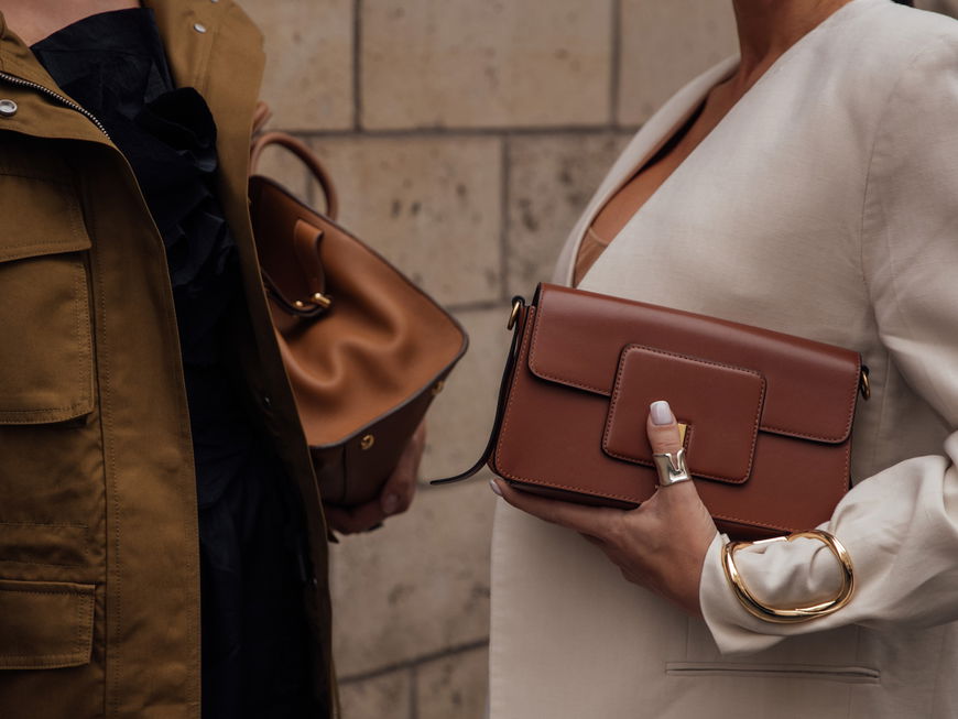 zwei Frauen mit braunen Handtaschen