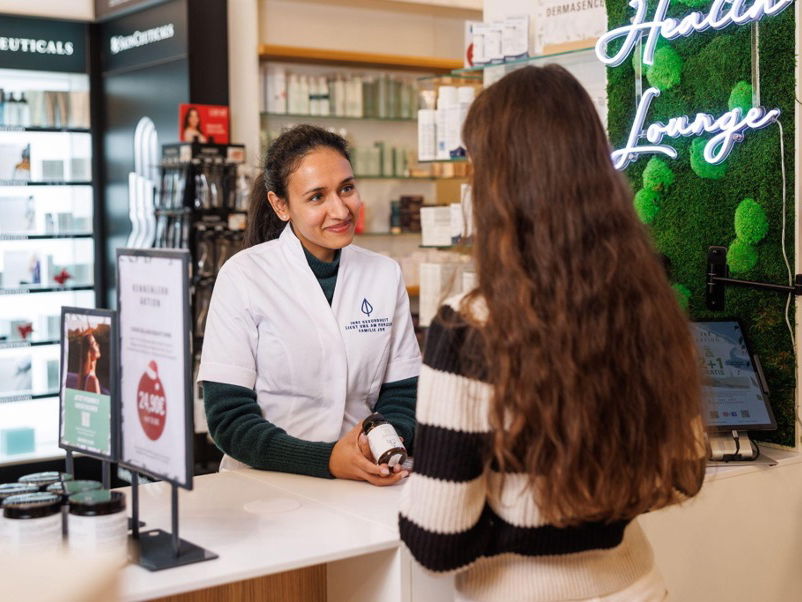 Eine junge Frau steht in der Apotheke