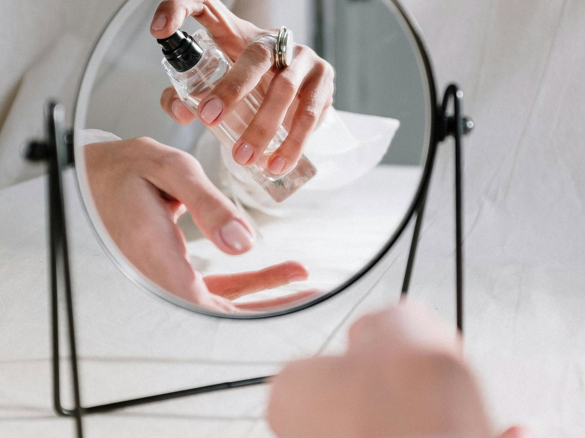 Frau trägt Parfum auf Handgelenk auf