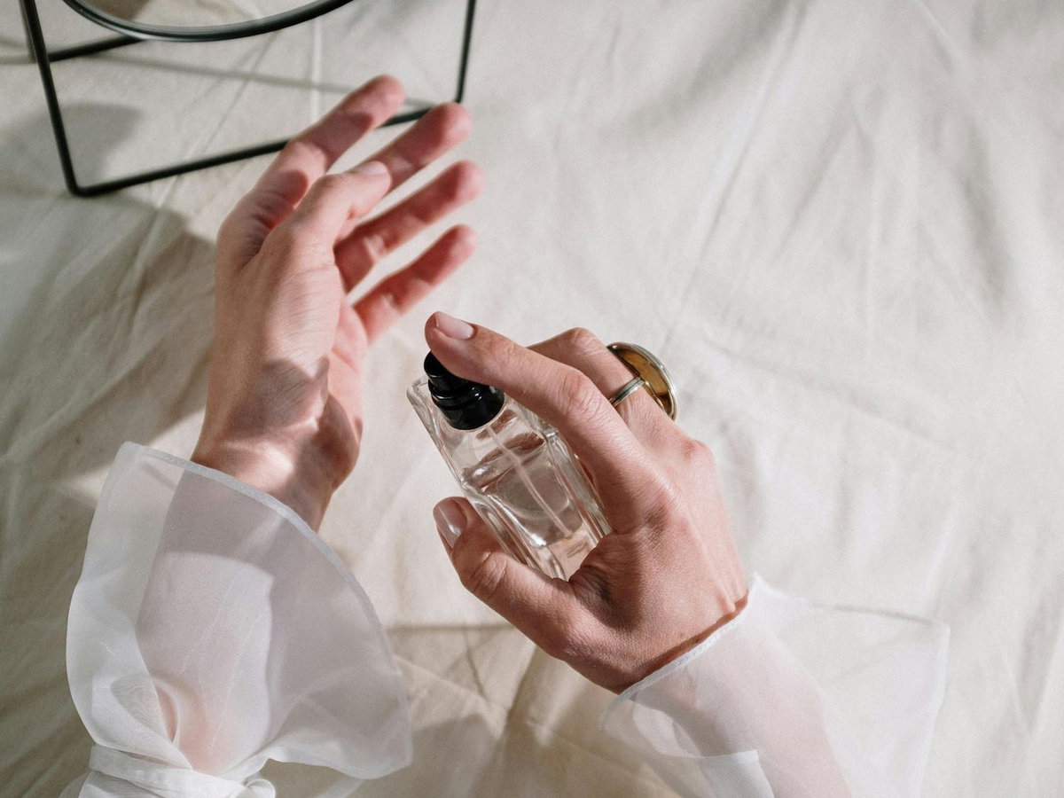 Frau sprüht Parfum auf