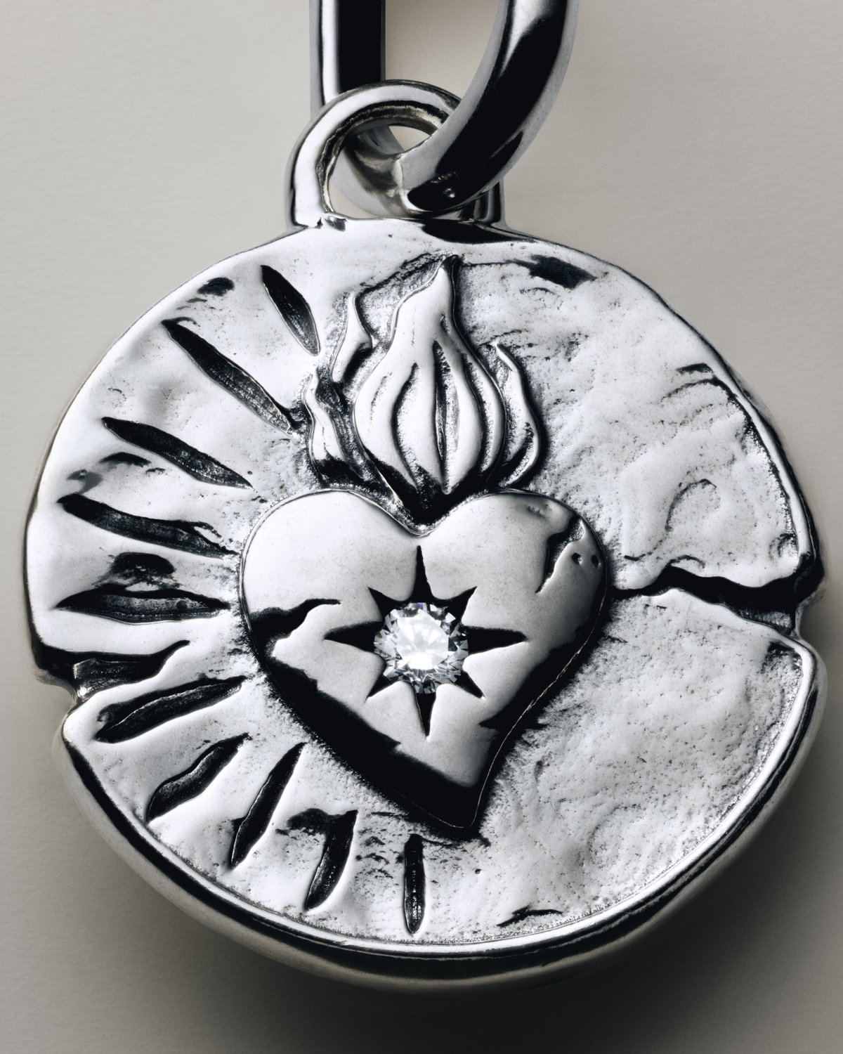 Wie passend: Auf dem Herz-Charm steht „Amor Vincit Omnia“ („Die Liebe besiegt alles“).