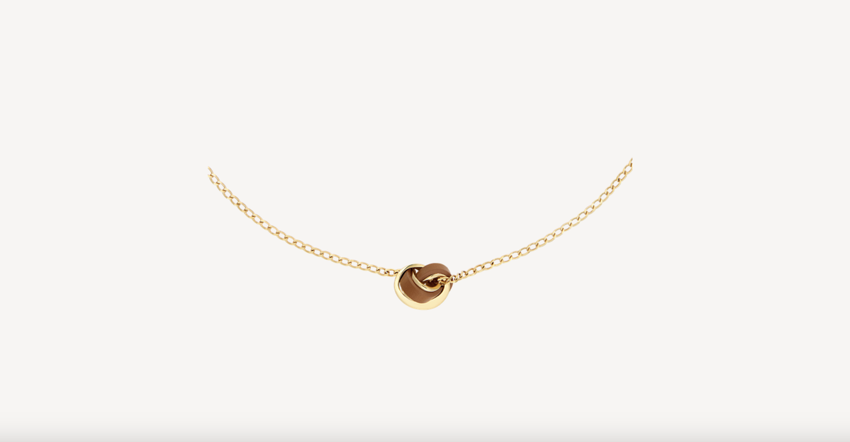 Die filigrane Orme Halskette von Polène besticht durch ihr skulpturales Design, das von der Natur inspiriert wurde und organische Formen mit zeitloser Eleganz verbindet. Das Schmuckstück ist aus vergoldetem Messing gefertigt und wird durch ein edles Lederdetail in der Farbe Camel ergänzt, das den charakteristischen Stil der Brand perfekt widerspiegelt. Diese Kette ist das ideale Geschenk für Minimalistinnen, die Wert auf handwerkliche Präzision und ein besonderes Accessoire mit Wiedererkennungswert legen.