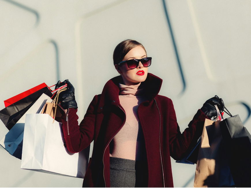 Eine Frau trägt mehrere Shopping-Tüten
