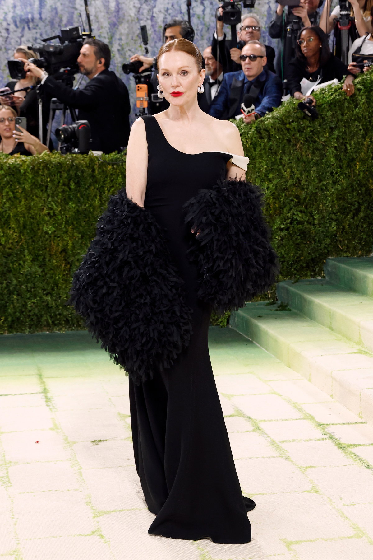 Julianne Moore begeisterte bei der diesjährigen Met Gala mit einem eleganten Look, der ihrem Ruf als Muse von Tom Ford alle Ehre machte. In einem schwarzen, figurbetonten Kleid mit einer Mermaid-Schleppe sorgte sie für einen subtilen, aber verführerischen Twist, indem sie den Schultergurt demütig fallen ließ und so das kontrastierende weiße Futter enthüllte—eine Hommage an John Singer Sargents berühmtes Gemälde „Porträt von Madame X“. Die beeindruckenden Diamantohrringe von Messika verliehen dem Ensemble zudem die nötige Dramatik, um dem Dresscode „Fashion is Art“ gerecht zu werden.
