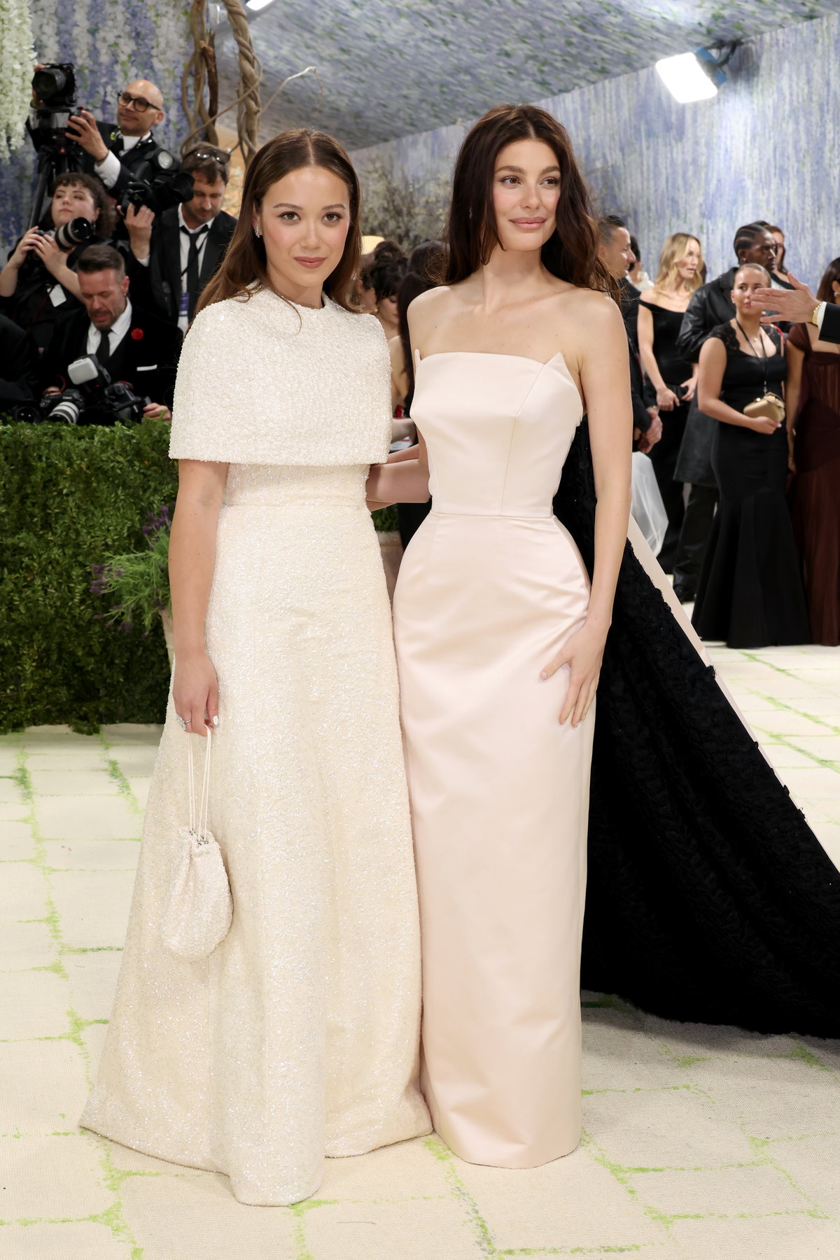 Musikerin Laufey und Schauspielerin Camila Morrone beeindruckten in maßgeschneiderten Kreationen von Tory Burch , die die komplexe Beziehung zwischen Kleidung und Kunst zelebrierten. Laufey trug ein Kleid aus elfenbeinfarbenem Crêpe, das komplett mit transparenten geprägten Pailletten bestickt war – dazu Diamantschmuck von Bucherer . Camila hingegen entschied sich für ein maßgefertigtes Kleid aus eisrosa Duchesse-Satin mit einer Schleppe, die mit 7.000 handgefertigten Seidenblumen bestickt war.