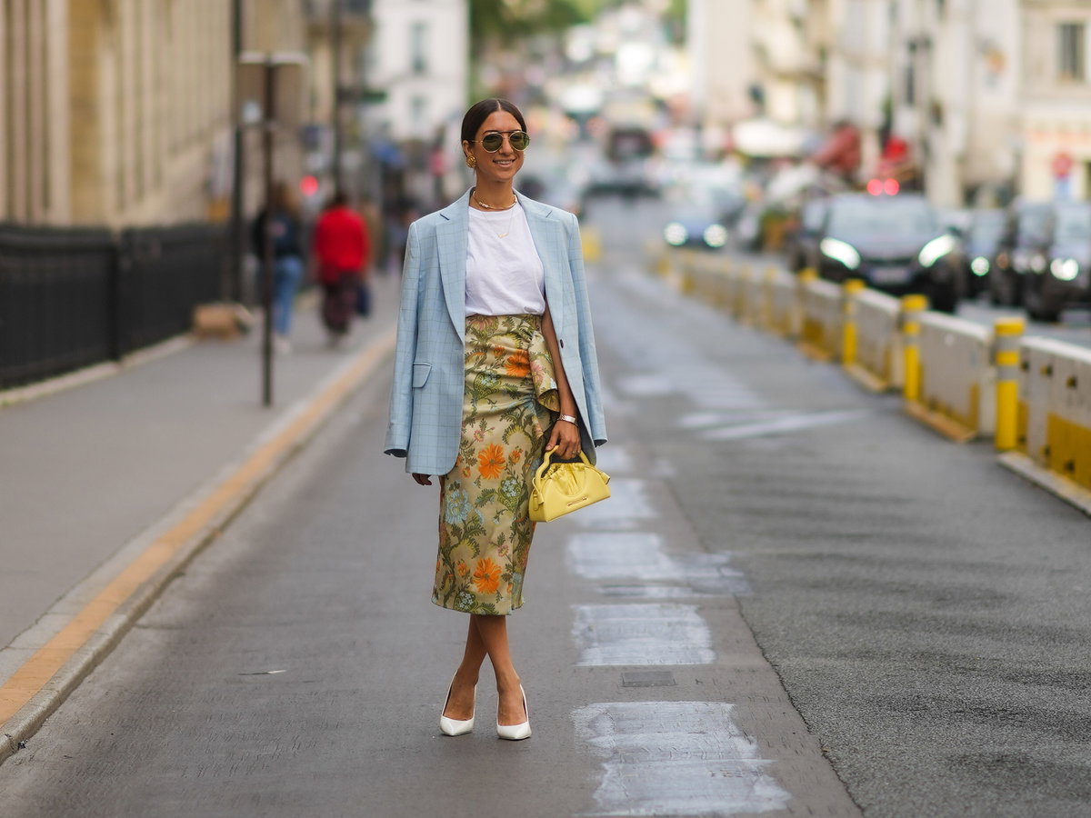 Frau-laeuft-in-einem-T-Shirt-einem-Rock-und-Blazer-auf-der-Strasse