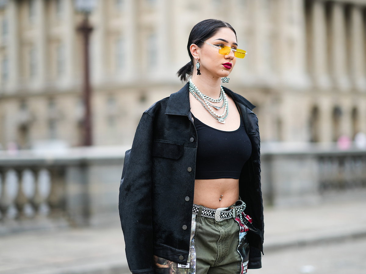 Lycia Lamini trägt ein bauchfreies Top und eine gelbe Sonnenbrille