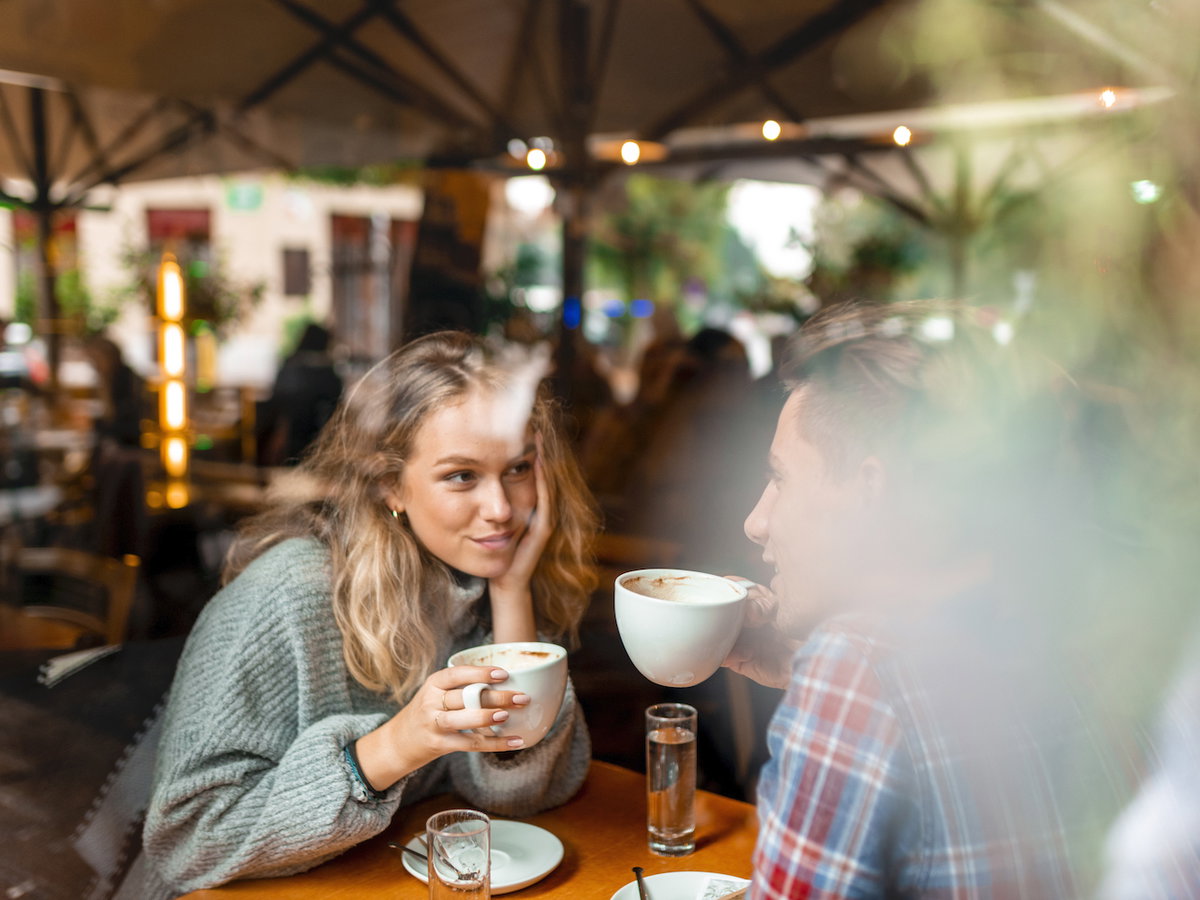 Mann und Frau sitzen sich gegenüber und trinken Kaffee
