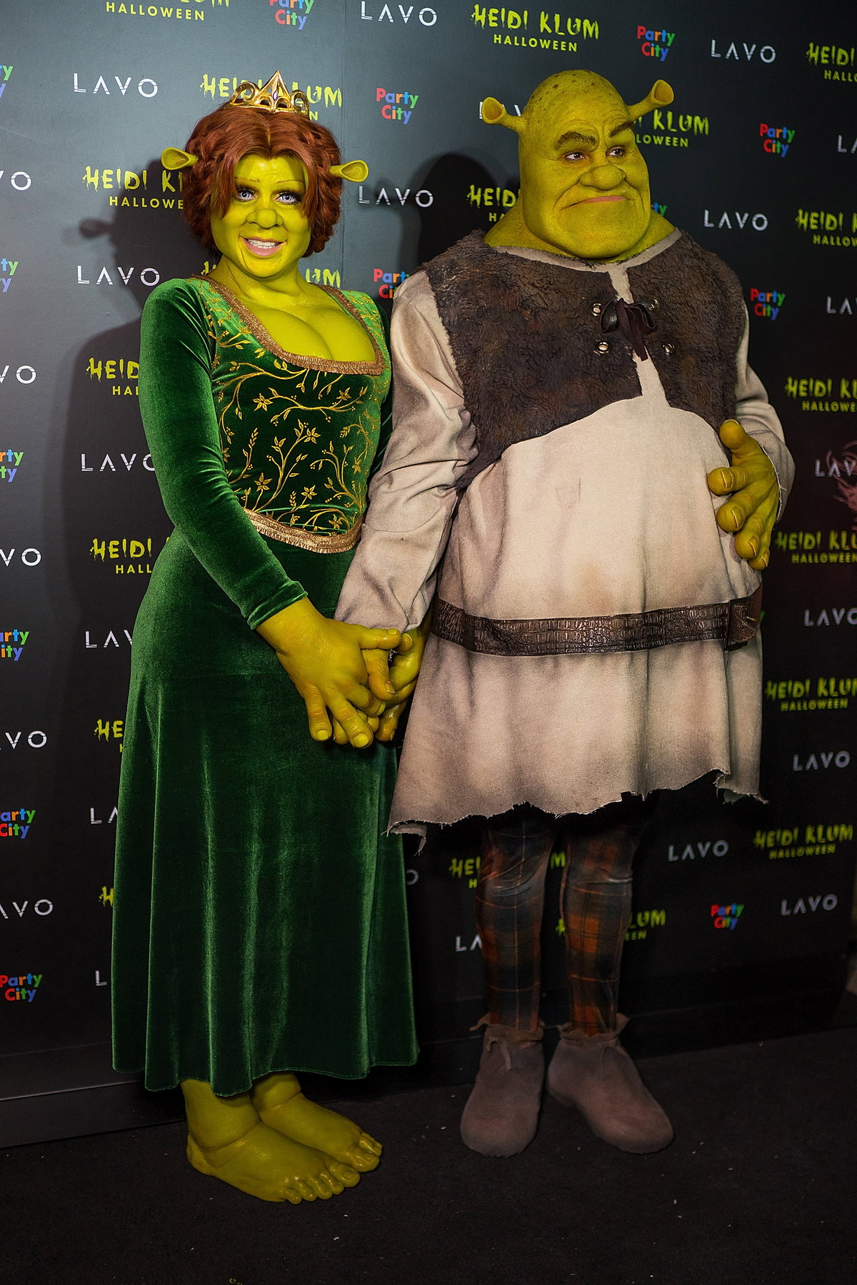 2018, Fiona und Shrek: Lange haben wir spekuliert und uns Hoffnungen auf ein bombenhaftes Partner-Kostüm gemacht – die in der letzten Halloween-Nacht keinesfalls enttäuscht wurden. Als Zeichentrick-Charaktere Shrek und Prinzessin Fiona verkleideten sich das Supermodel und ihr Ehemann Tom Kaulitz dieses Jahr. Doch Heidi wäre nicht Heidi, wenn sie für ihre Fans nicht noch einen Ass im Ärmel hätte: Das Pärchen blieb nicht alleine, ein Kinderwagen mit vielen Mini-Shreks begleitete sie auf dem roten Teppich!