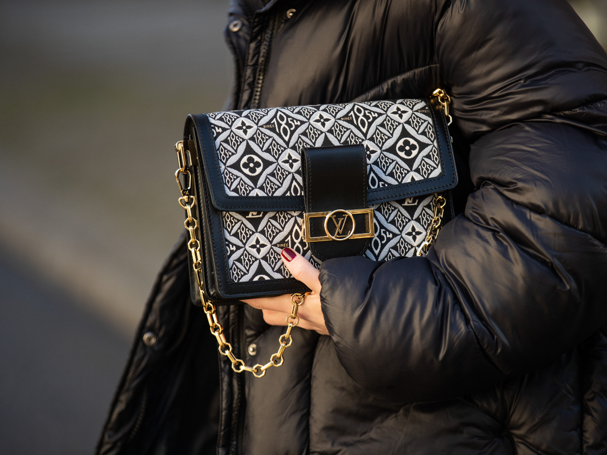 Louis Vuitton Tasche und Hand mit rotem Nagellack