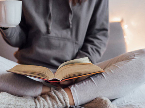 Frau im Schneidersitz liest Buch