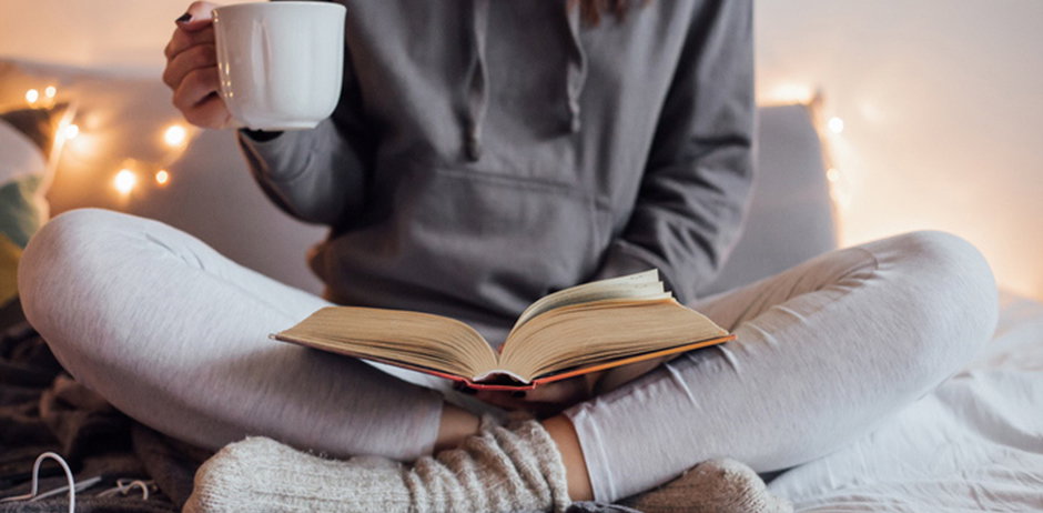 Frau im Schneidersitz liest Buch