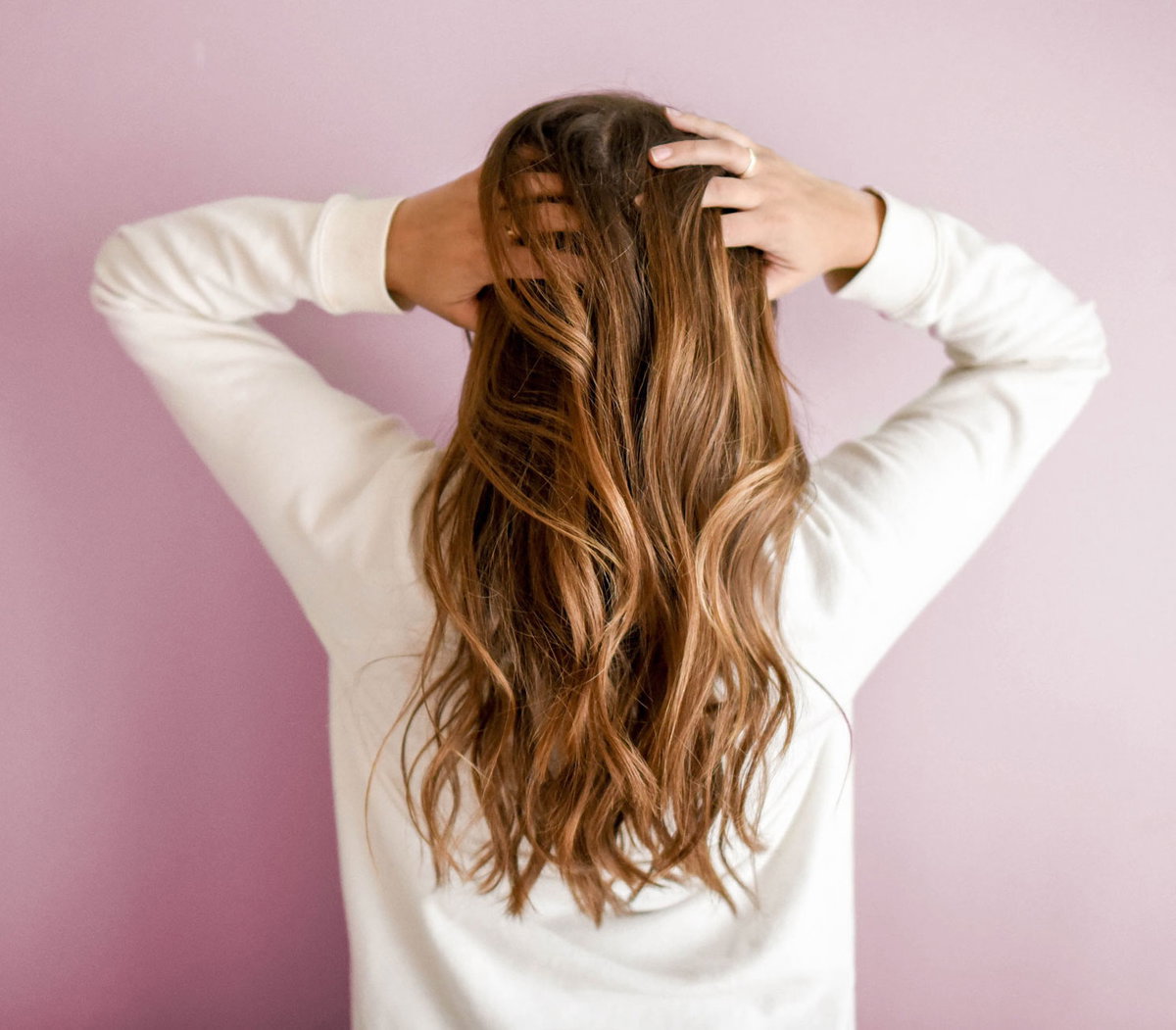 Frau greift sich in ihre langen Haare