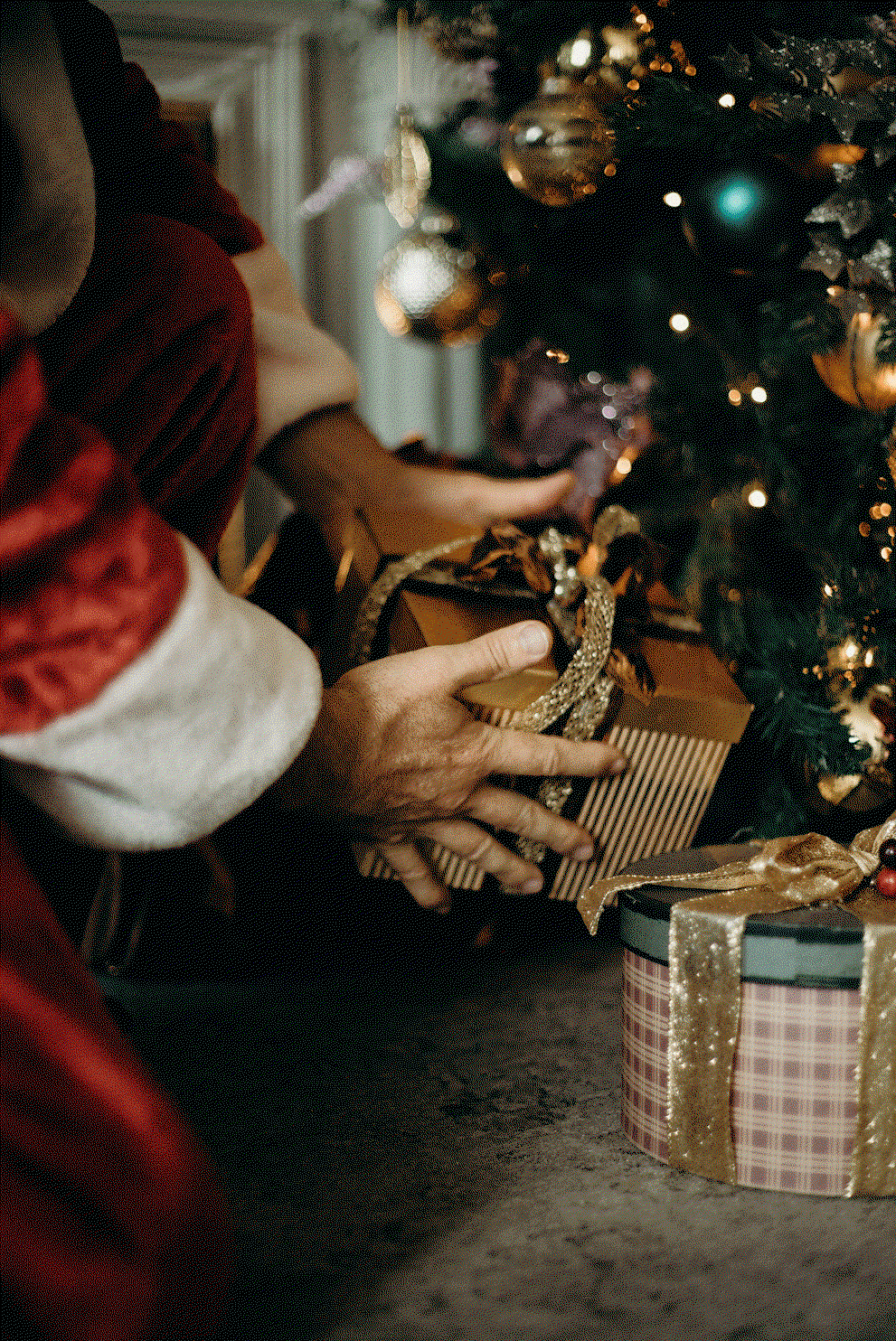 Weihnachtsmann legt Geschenke unter den Christbaum